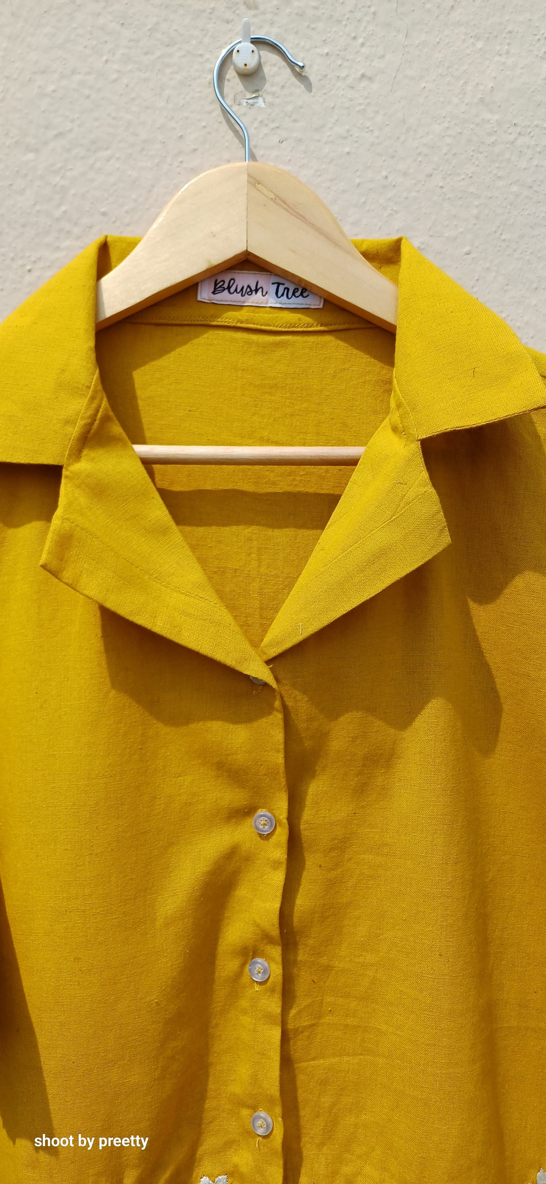 Yellow pure cotton shirt on hanger with collar and button details, highlighting bright and stylish casual wear.